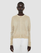 Woman wearing a beige knit cardigan on a white background