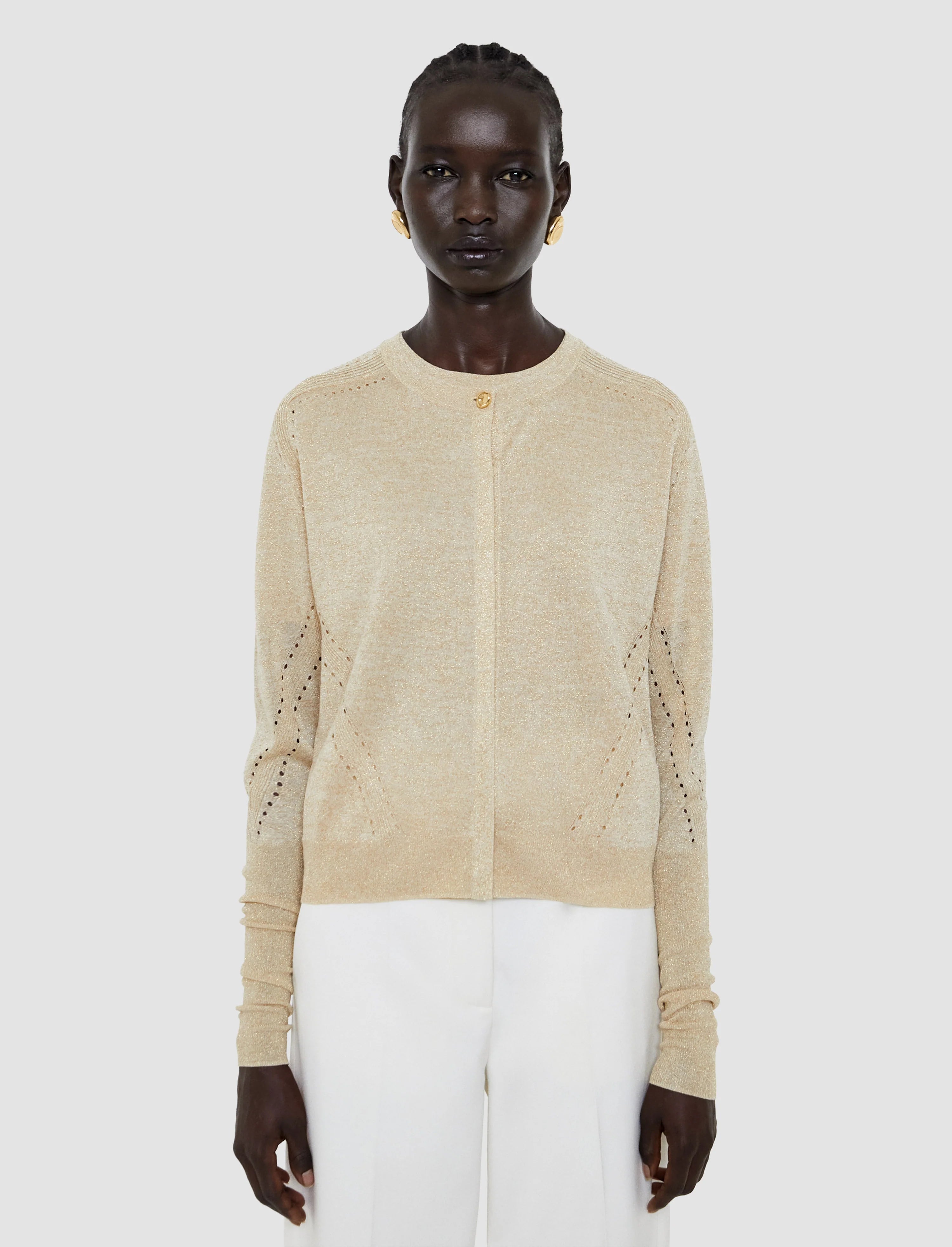 Woman wearing a beige knit cardigan on a white background