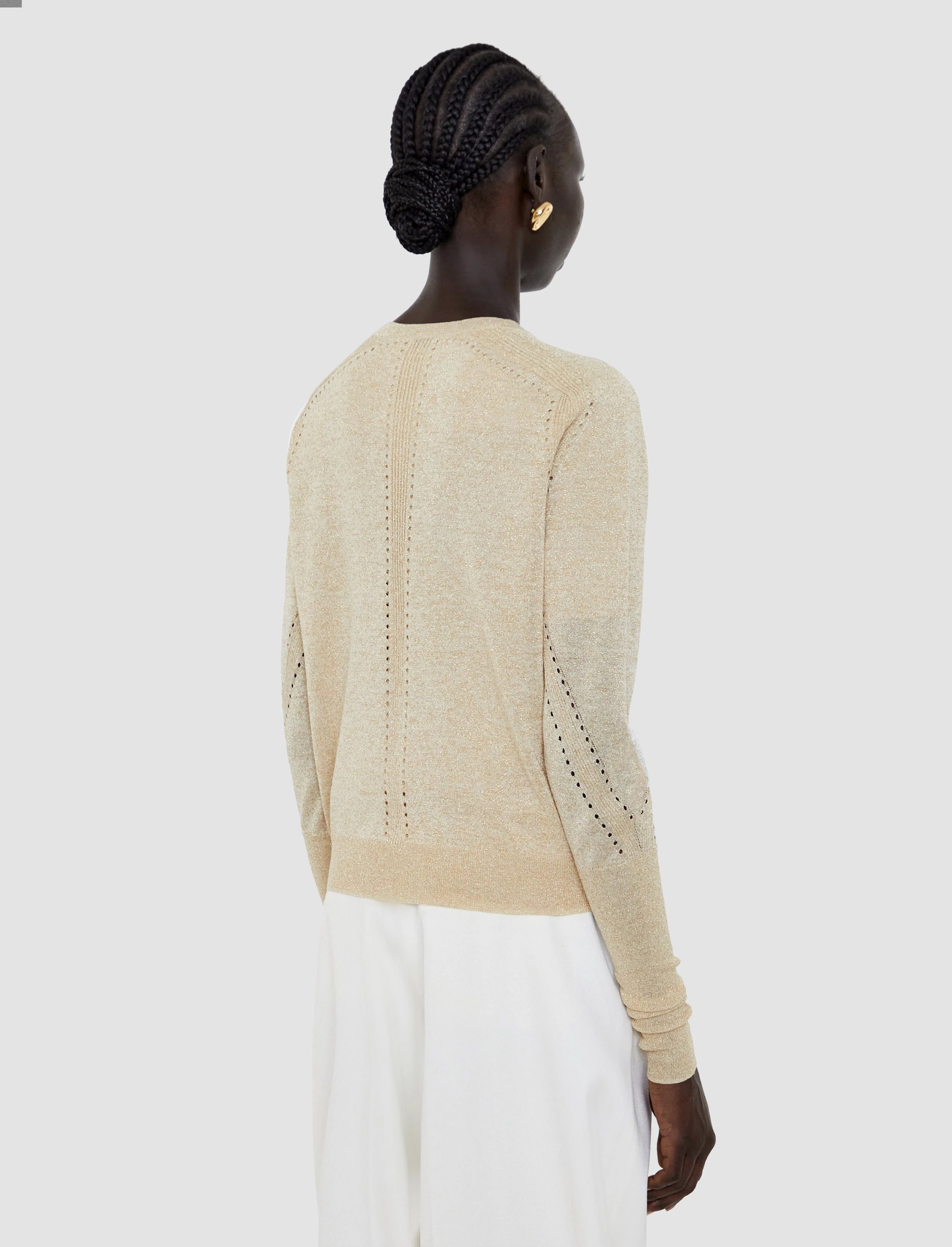 Woman wearing a beige sweater with a white background