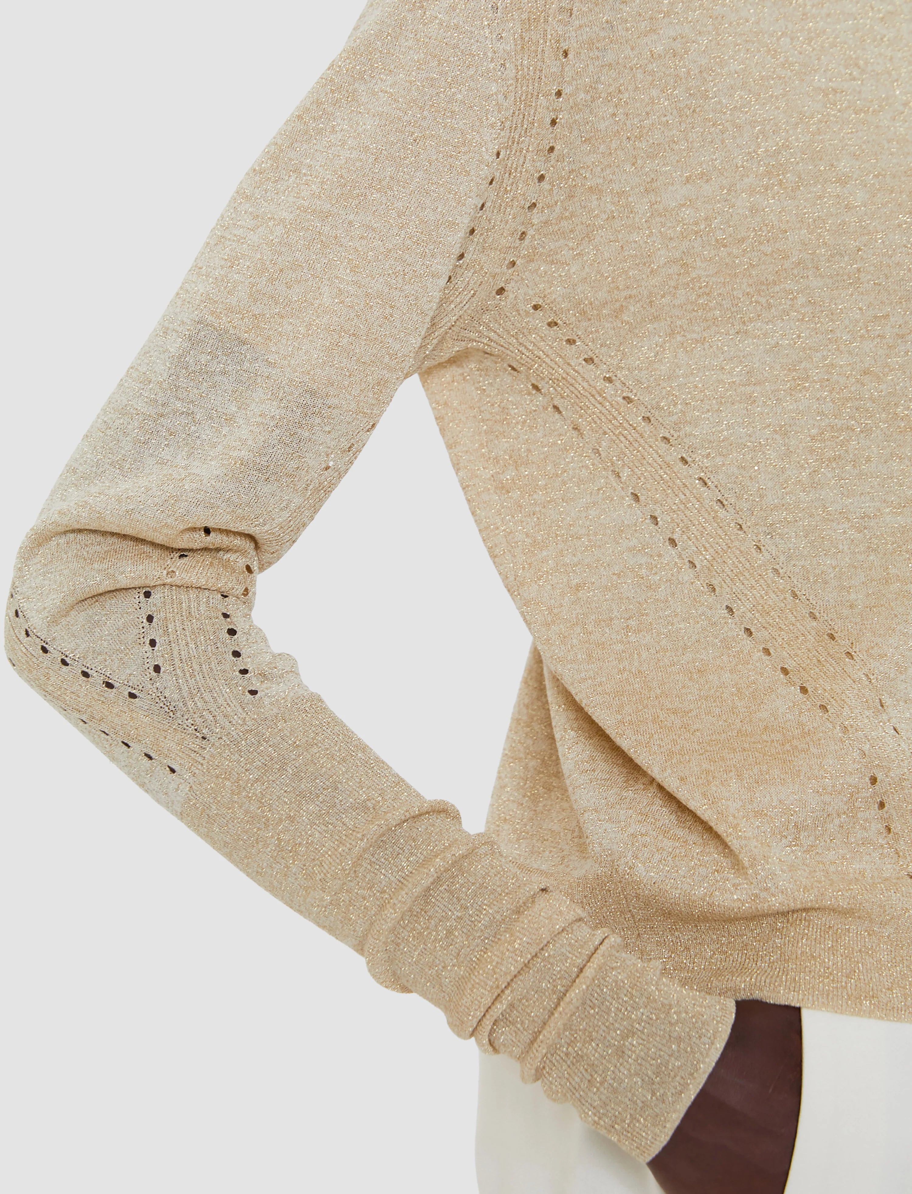 Close-up of beige fabric with stitching detail on a white background