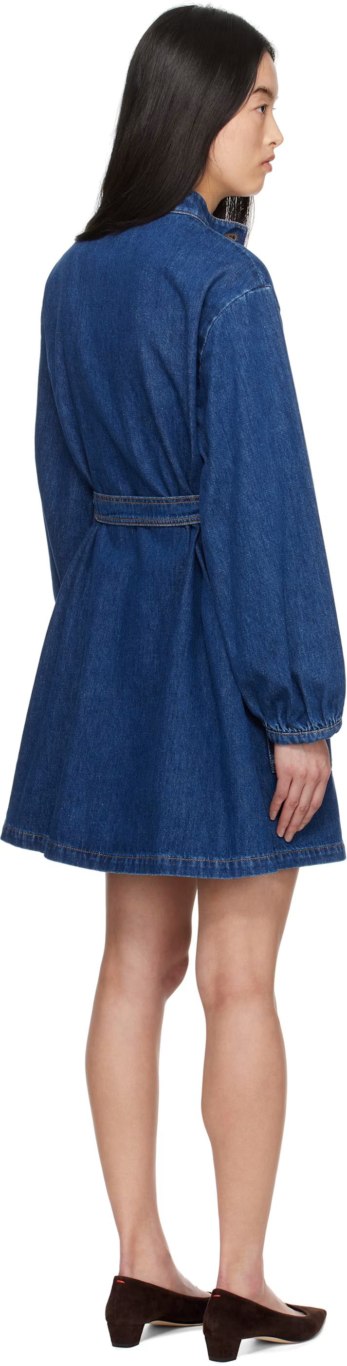 Woman wearing a blue denim dress with long sleeves and a belt.