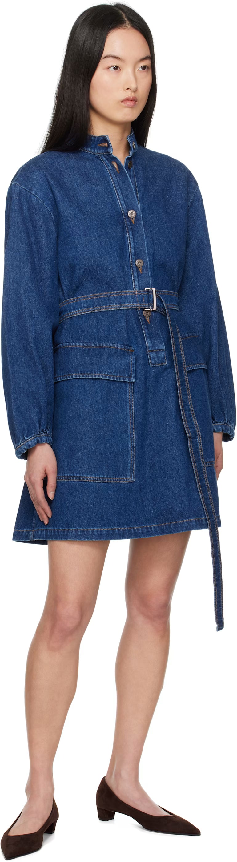 Woman wearing a blue denim dress with a belt on a white background