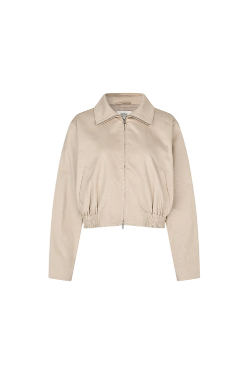 A cropped beige jacket with a collar, front zipper, and gathered elastic hem, shown on a plain white background.