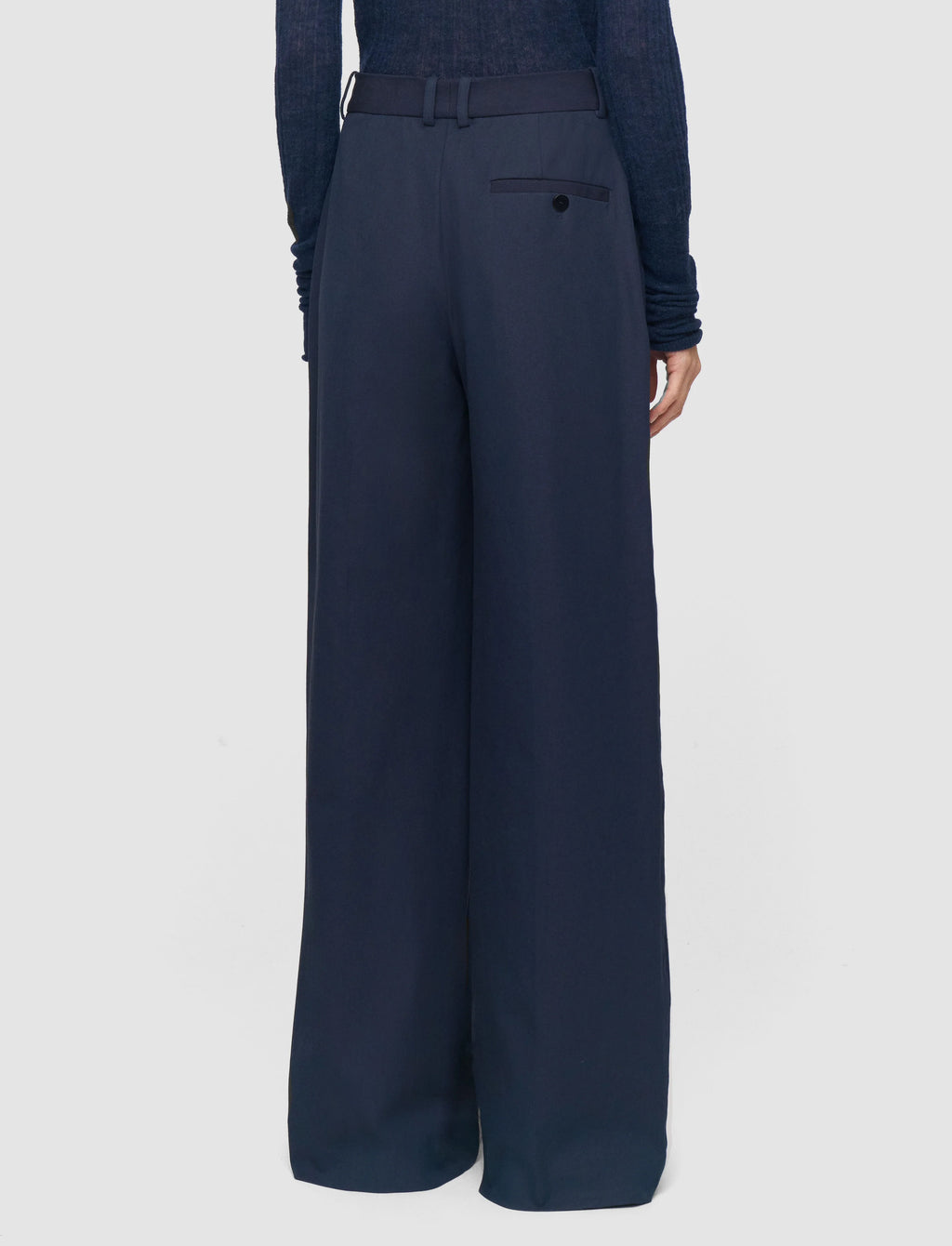 Navy blue wide-leg pants worn by a person on a light gray background