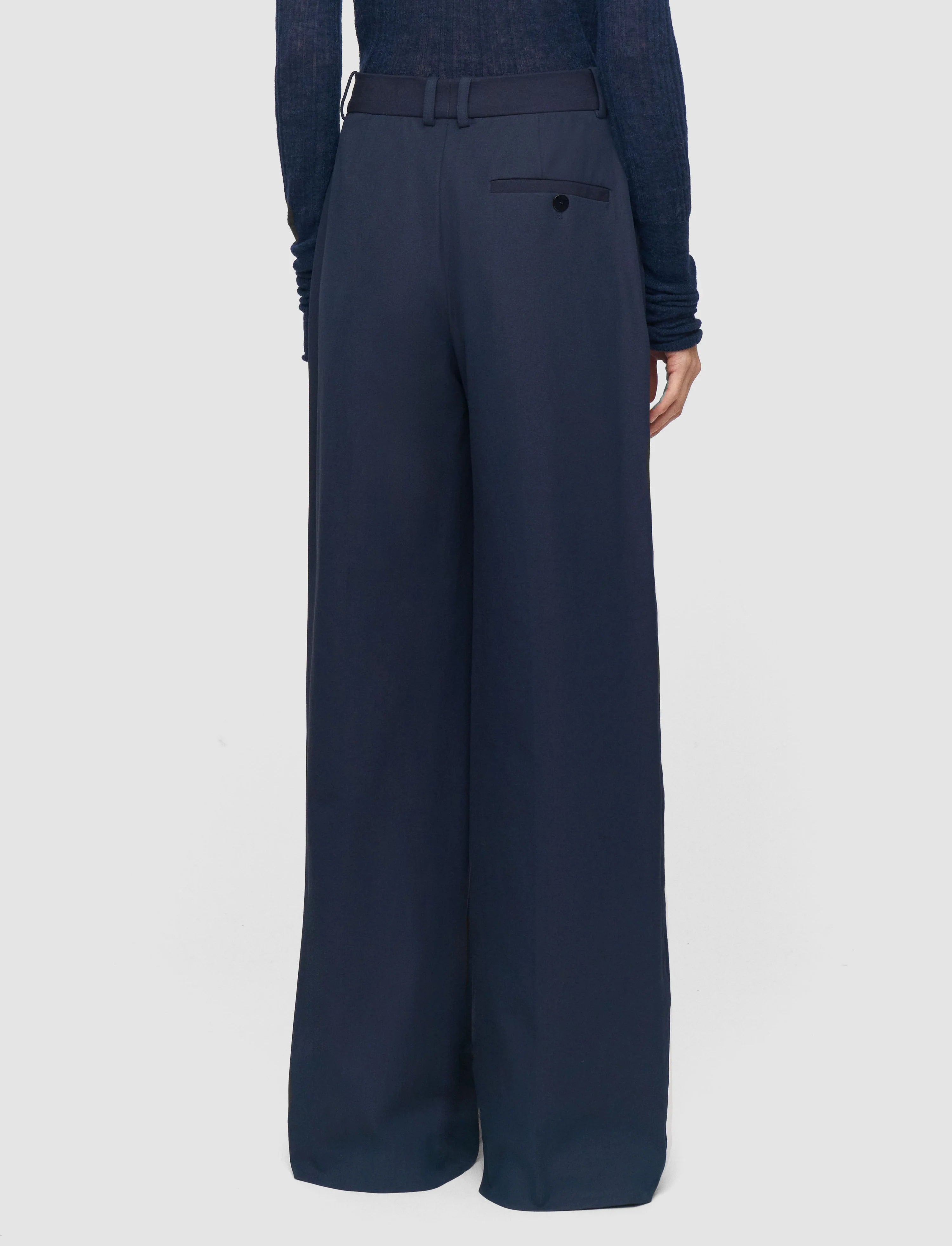 Navy blue wide-leg pants worn by a person on a light gray background