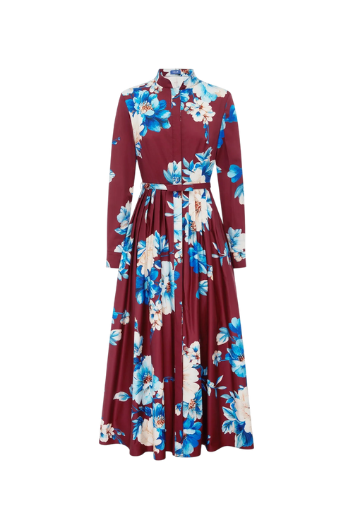 A long-sleeved maxi dress with a high collar and a matching waist tie, featuring a bold floral print in blue, cream, and white over a deep burgundy base, shown against a plain white background.