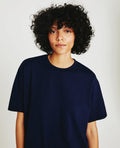 A person wearing a deep navy, short-sleeved crew neck t-shirt.